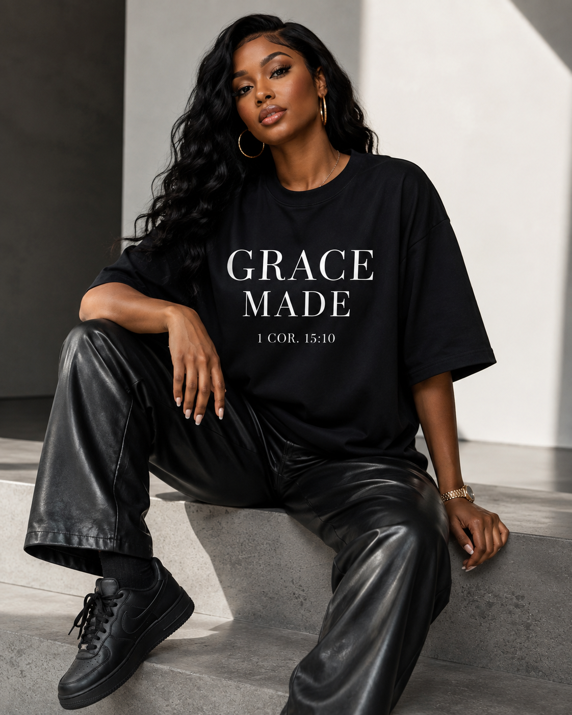 Model wearing a black Grace Made t-shirt with 1 Corinthians 15:10