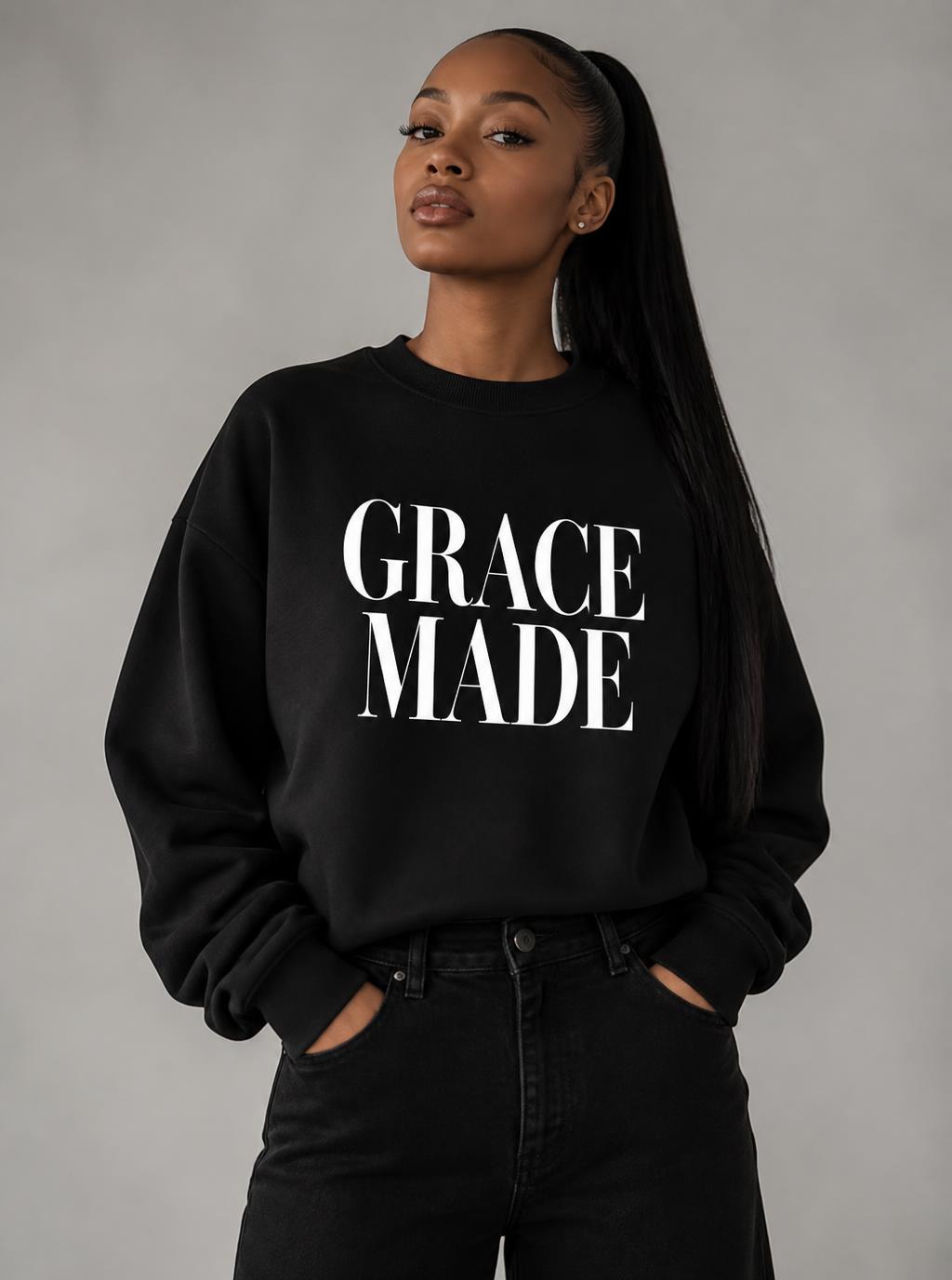 Light-skinned Black woman with long ponytail in black Grace Made crewneck and black jeans